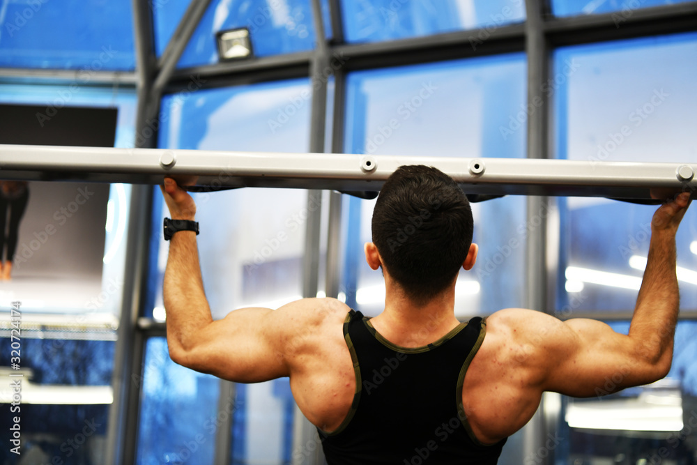 male athlete doing physical exercises for the development of the body in the gym male athlete doing physical exercises for the development of the body in the gym