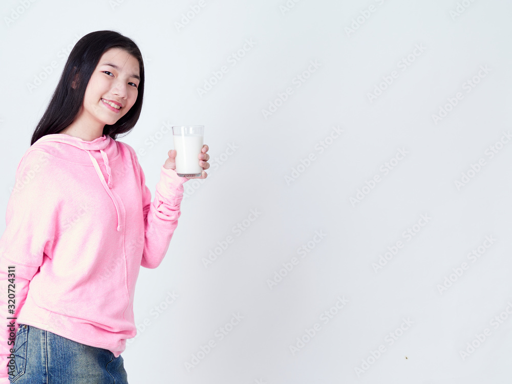 Teenage girls holding a glass of milk. Teenage girls holding a glass of milk.