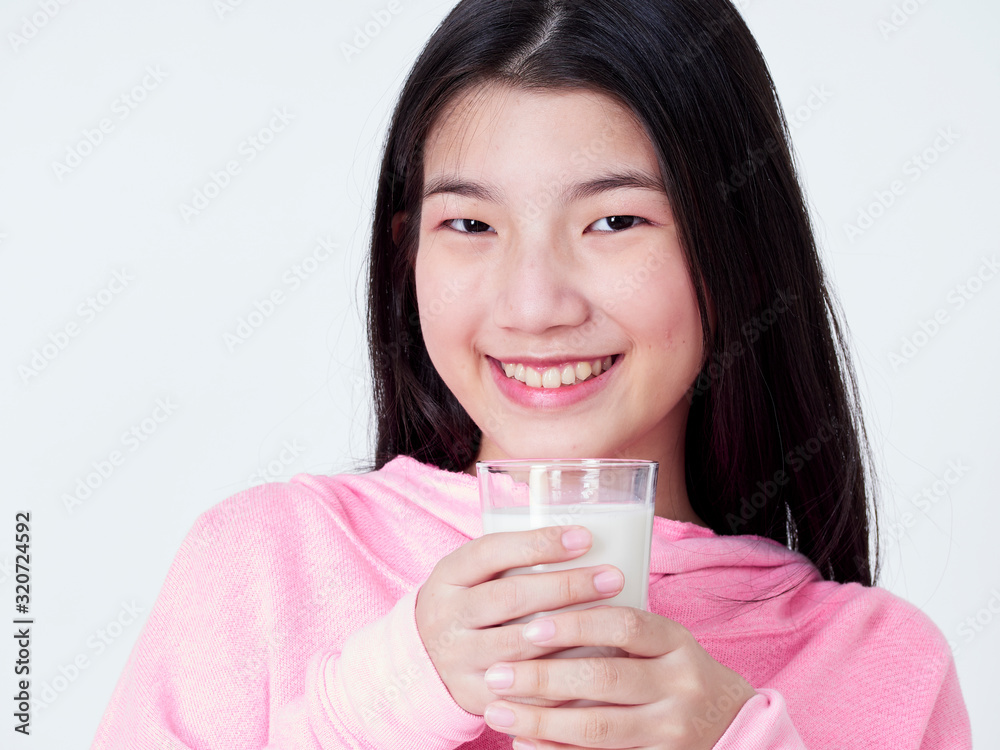 Teenage girls holding a glass of milk. Teenage girls holding a glass of milk.