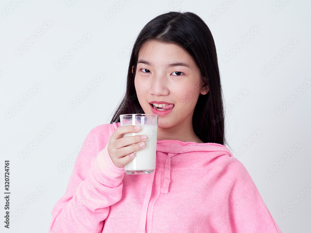 Teenage girls holding a glass of milk. Teenage girls holding a glass of milk.