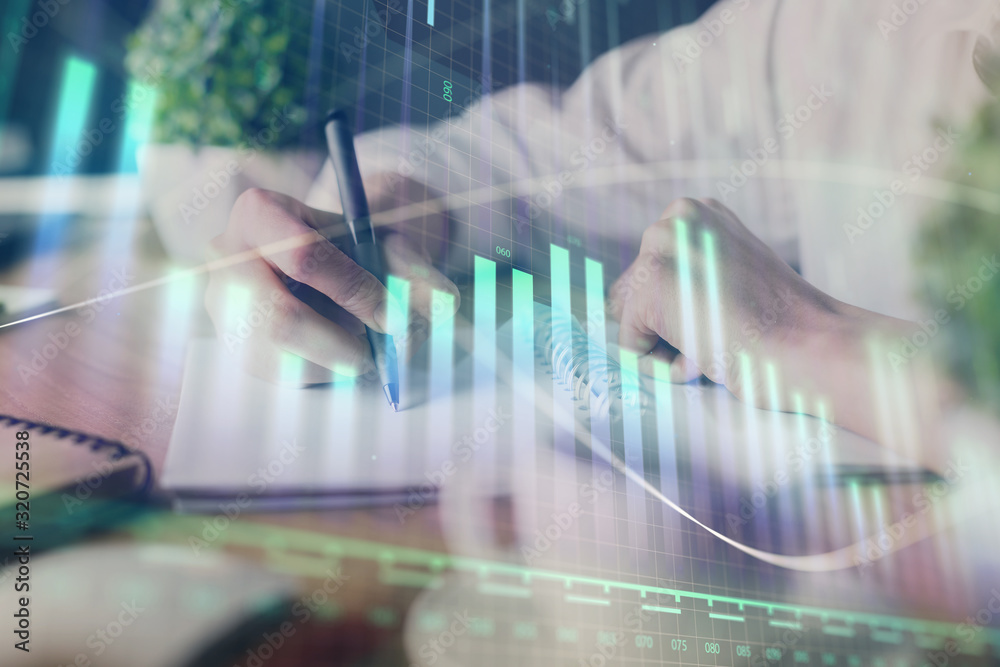 Financial forex graph displayed on hands taking notes background. Concept of research. Double exposure Financial forex graph displayed on hands taking notes background. Concept of research. Double exposure