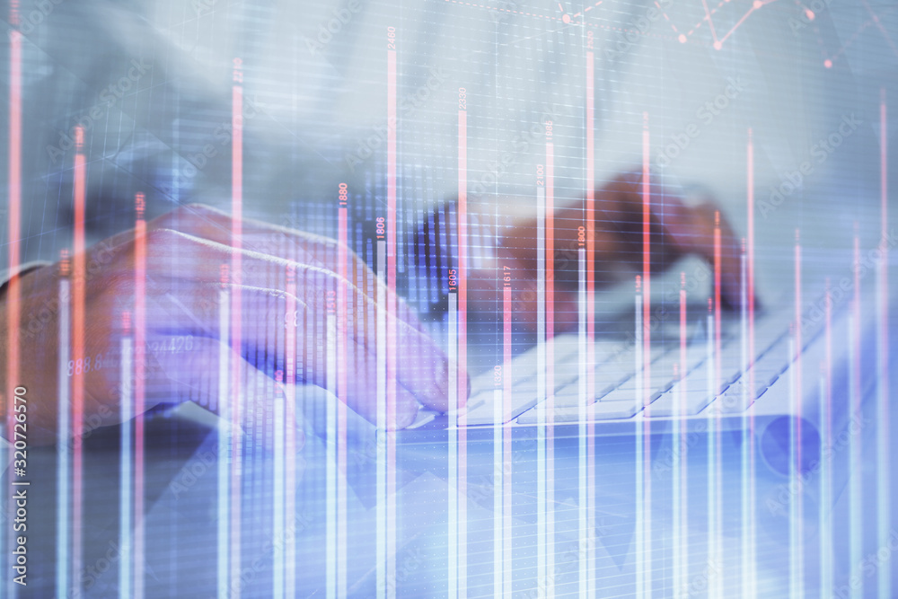Double exposure of graph with man typing on computer in office on background. Concept of hard work. Double exposure of graph with man typing on computer in office on background. Concept of hard work.