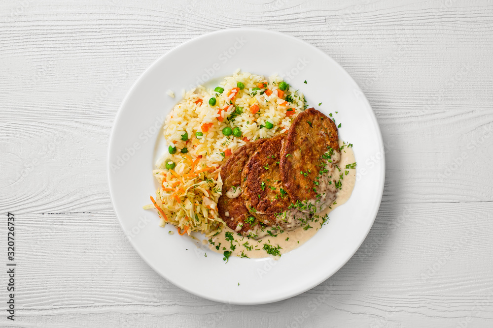 Top view of plate with liver cutlet, rice with peas and pickled cabbage Top view of plate with liver cutlet, rice with peas and pickled cabbage
