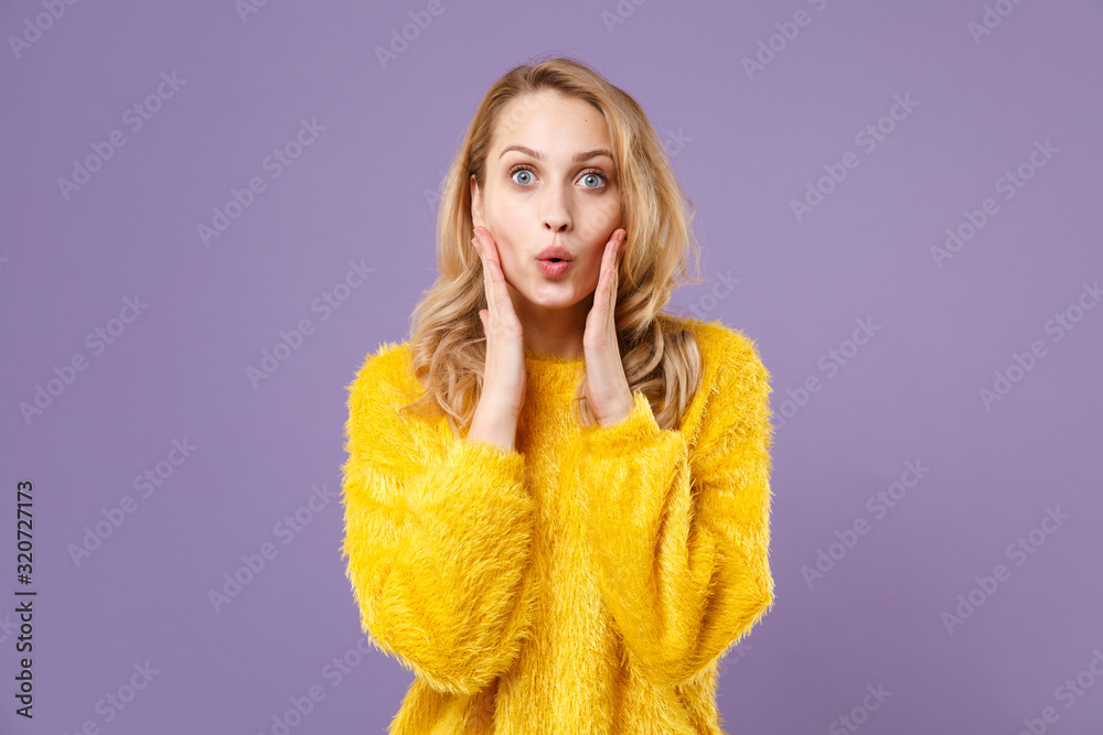 Shocked young woman girl in yellow fur sweater posing isolated on pastel violet wall background studio portrait. People sincere emotions lifestyle concept. Mock up copy space. Put hands on cheeks. Shocked young woman girl in yellow fur sweater posing isolated on pastel violet wall background studio portrait. People sincere emotions lifestyle concept. Mock up copy space. Put hands on cheeks.