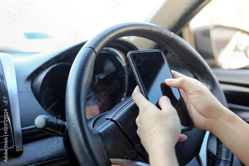 women using smart phone mobile phone in car while driving.