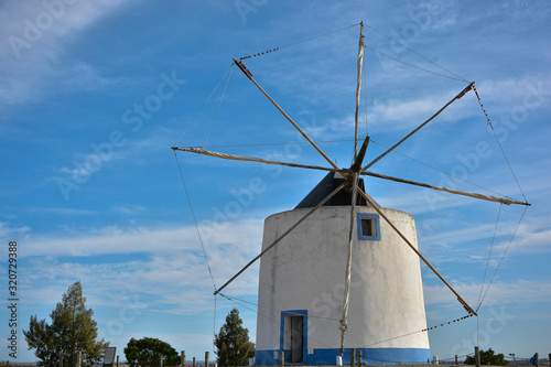 Old windmill blades without candles on blue sky background.