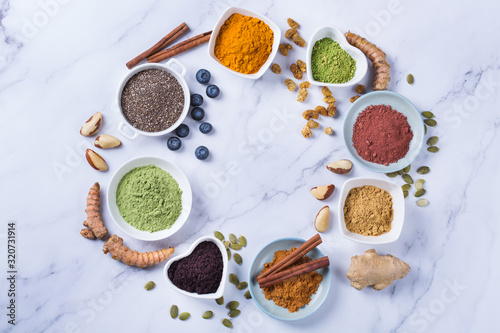 Assortment of superfood powder, acai, turmeric, ginger, matcha, cinnamon, wheat photo