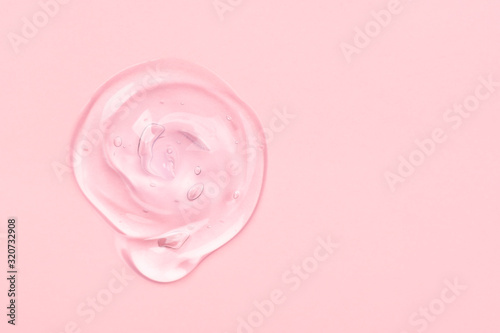 Clear gel drop or smear isolated on pink background. photo