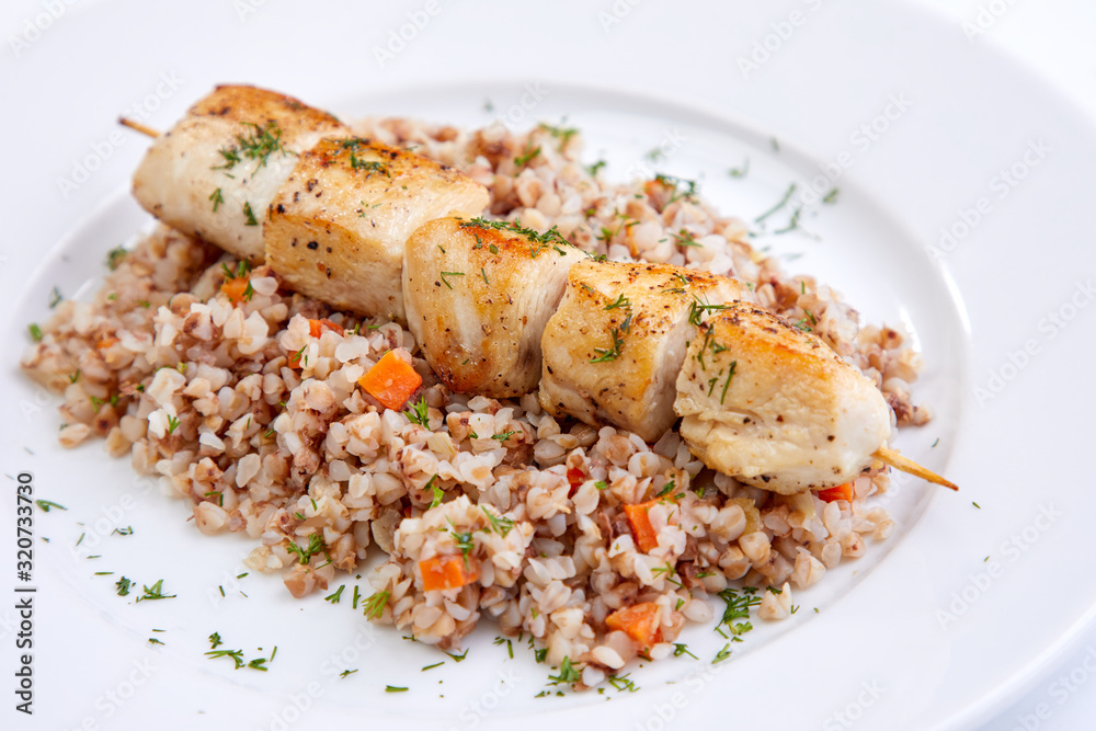 chicken kebab with buckwheat on the white plate chicken kebab with buckwheat on the white plate