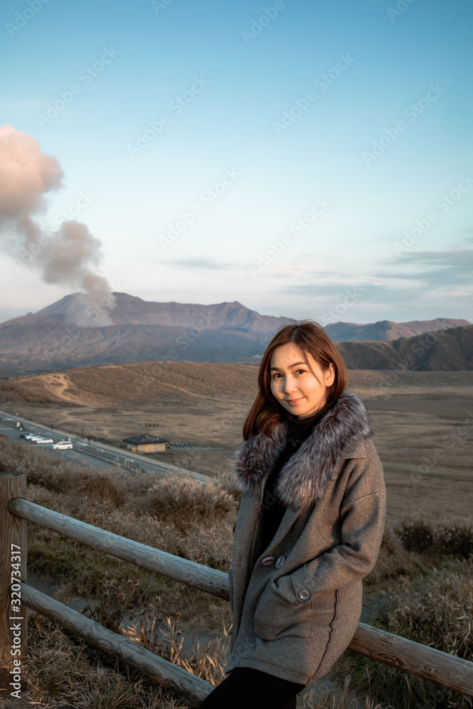 Lonely girl in Area of Aso active volcano background with smoke at Mount Aso Nakadake, Kumamoto, kyushu, Japan. (Photo grain some noise on film colour)
