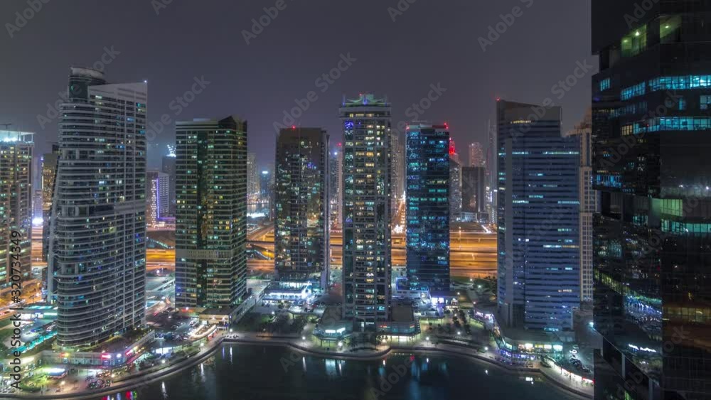 Residential and office buildings in Jumeirah lake towers district night timelapse in Dubai. Aerial panoramic view from above with modern skyscrapers Residential and office buildings in Jumeirah lake towers district night timelapse in Dubai. Aerial panoramic view from above with modern skyscrapers