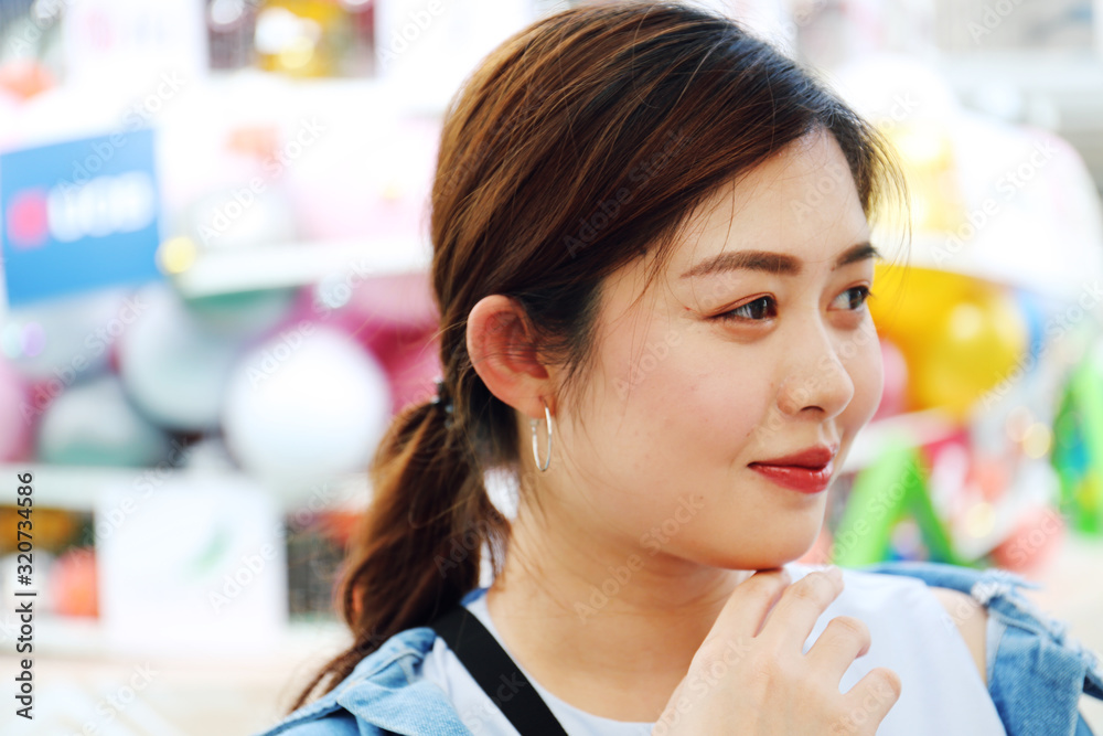 Young Asia woman smile portrait and looking traveling on walking street.