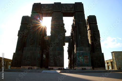 Bright Sun Shining Through the Chronicle of Georgia, a Massive Monument Created by Zurab Tsereteli in 1985 Located on the Hilltop near Tbilisi, Georgia photo