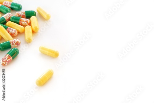 A lot of multi-colored medical capsules with medicine on a white background. The concept of treatment, recovery, medicine, pharmacology. Close-up, copy space for text.