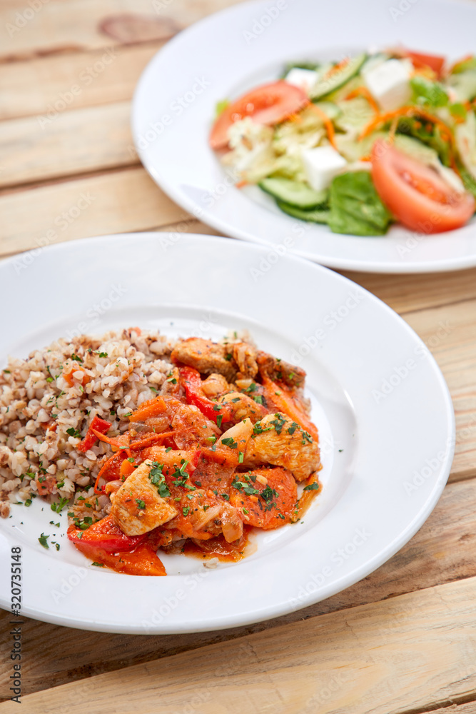 meat with buckwheat and salad on the wooden background