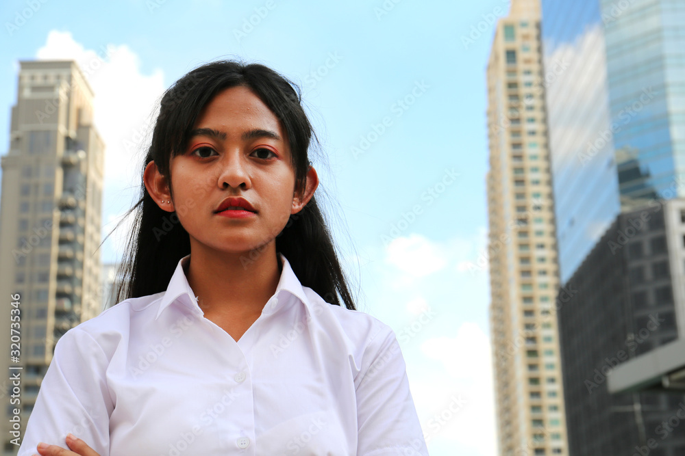 Beautiful Asia girl teen smile portrait and building in the city background. Beautiful Asia girl teen smile portrait and building in the city background.