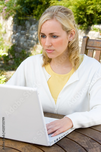 Thoughtful Girl Young Woman Using a White Laptop in Her Garden at Home