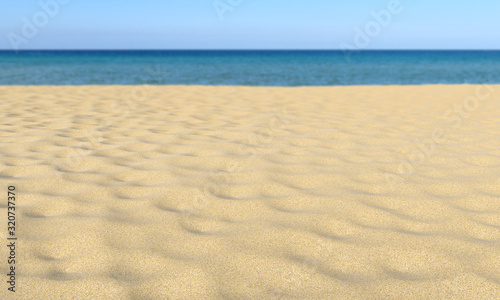 Sand on sandy beach, blue sky and sea, shallow dof