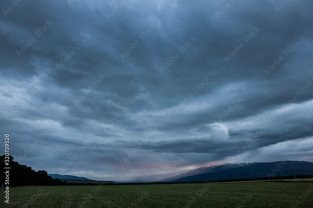 Tarras New Zealand coast. Thunder and rain clouds at twilight Tarras New Zealand coast. Thunder and rain clouds at twilight