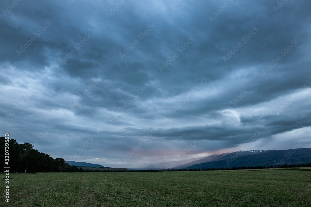 Tarras New Zealand coast. Thunder and rain clouds at twilight Tarras New Zealand coast. Thunder and rain clouds at twilight