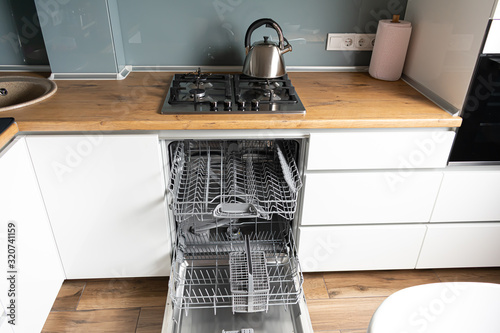 Open dishwasher in the white kitchen