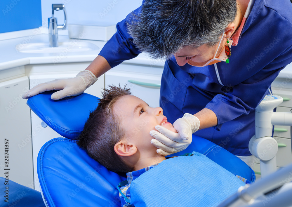 Dental visit to a child with an open mouth sitting in an inclined chair Dental visit to a child with an open mouth sitting in an inclined chair