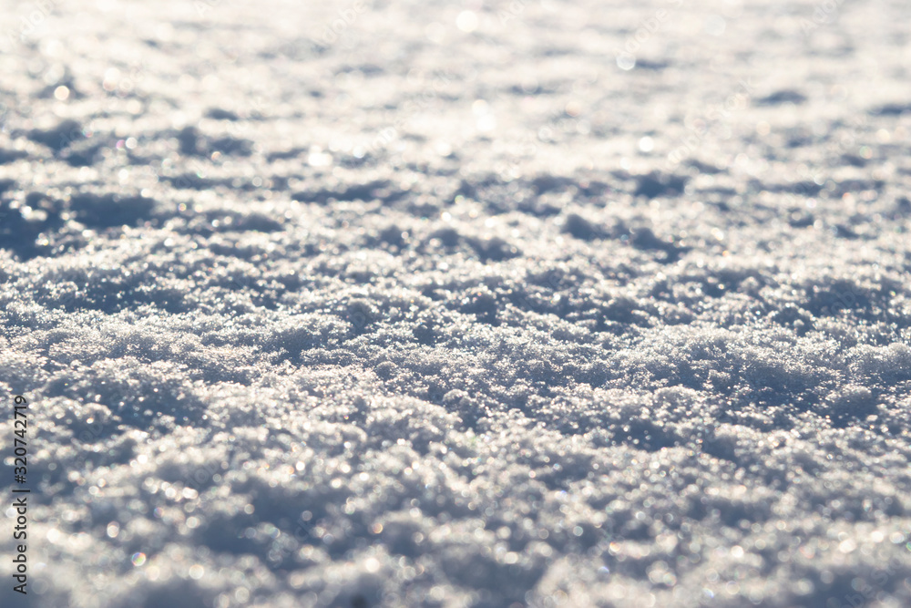 Background of fresh white snow closeup. Winter snowflakes texture. Snow white texture winter background of fresh cold ice. Icy surface pattern. Shiny snow with bokeh and blurred background