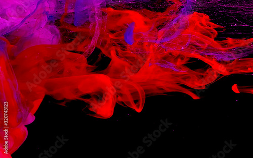 Colored space background. Red and purple watercolor ink in water on a black background.