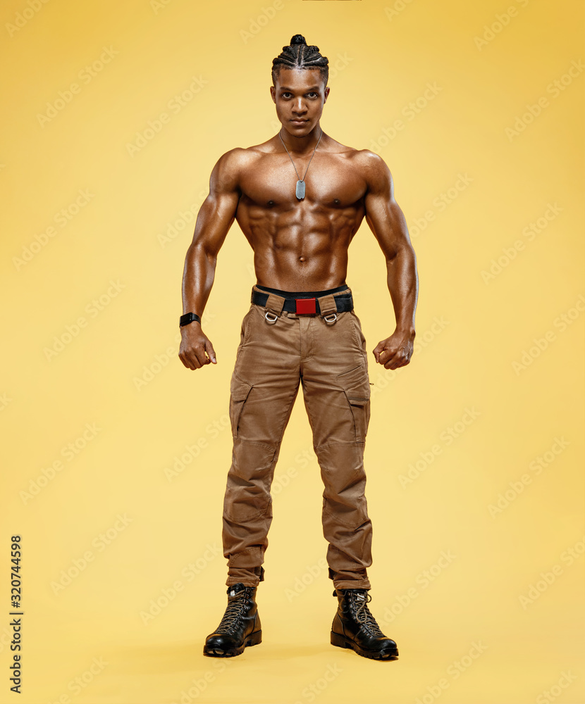 Muscular man shirtless. Photo of handsome man with perfect body after training on yellow background. Strength and motivation. Full length Muscular man shirtless. Photo of handsome man with perfect body after training on yellow background. Strength and motivation. Full length
