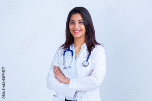 Medical concept of Asian beautiful female doctor in white coat with stethoscope, waist up. Medical student. Woman hospital worker looking at camera and smiling, studio, gray background photo