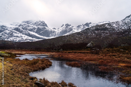Mirror lake and snowy mountains. Lofoten islands nature landscape  Norway.