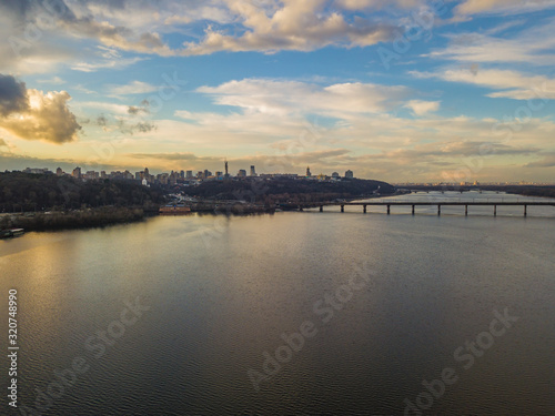 Aerial drone view. View of the Dnieper and the right bank of Kiev in the sunset. The sky is reflected in the water.
