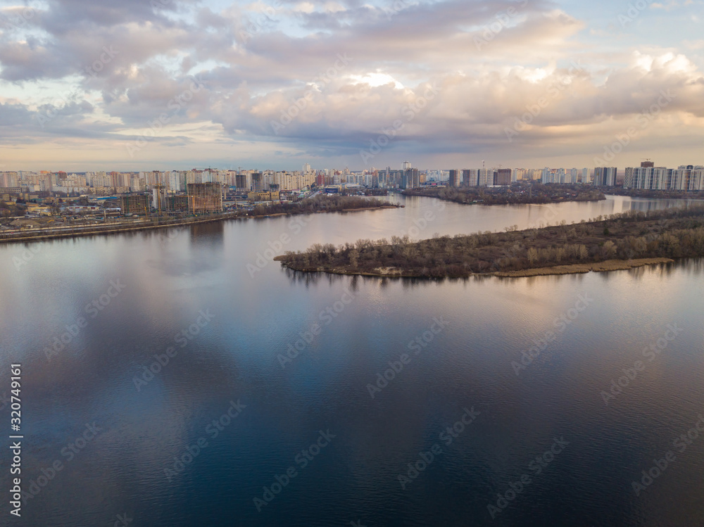 Aerial drone view. View of the Dnieper and the left bank of Kiev in the sunset. The sky is reflected in the water.