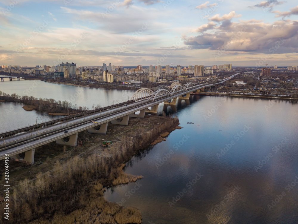 Aerial drone view. Darnitsky railway-automobile bridge in Kiev in the sunset light.