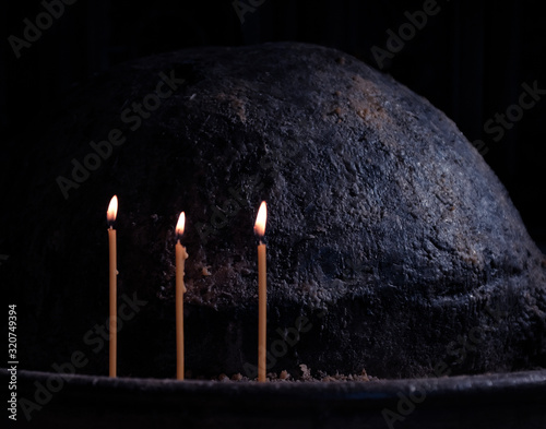 Foto 3 lit candles in dark church placed in sand in remembrance of loved ones