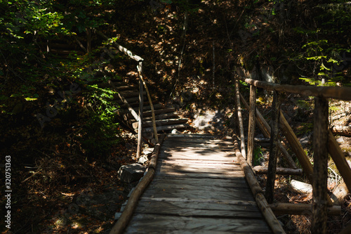 Wooden bridge with steps on the eco-trail along the rocks and mountain river in Bulgaria  Smolyan city. Equipped tourist road through the forest for sightseeing tours and walks