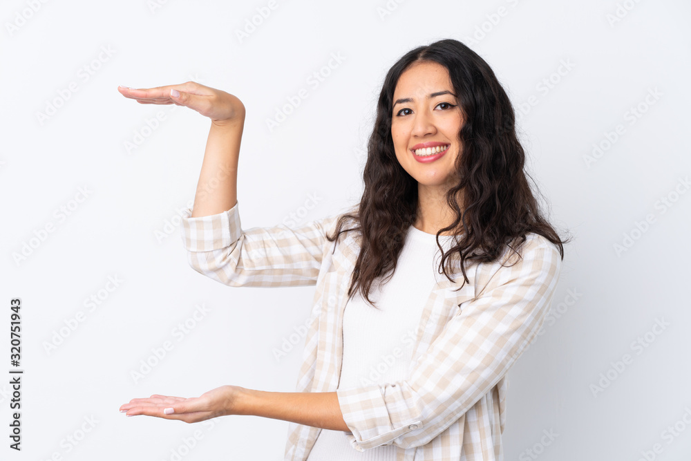 Mixed race woman over isolated white background holding copyspace to insert an ad Mixed race woman over isolated white background holding copyspace to insert an ad