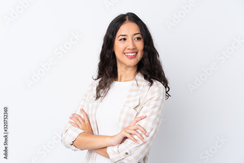 Mixed race woman over isolated white background with arms crossed and happy