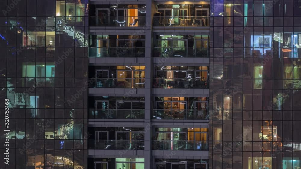 Night view of exterior apartment building timelapse. High rise skyscraper with blinking lights in windows with people moving inside. Zoom out Night view of exterior apartment building timelapse. High rise skyscraper with blinking lights in windows with people moving inside. Zoom out