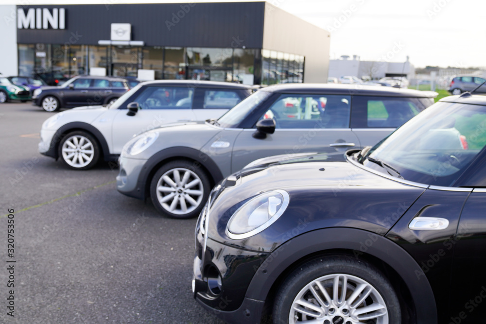 Mini new car parked outside a Mini Cooper dealership logo sign for sale Stock Photo Adobe Stock