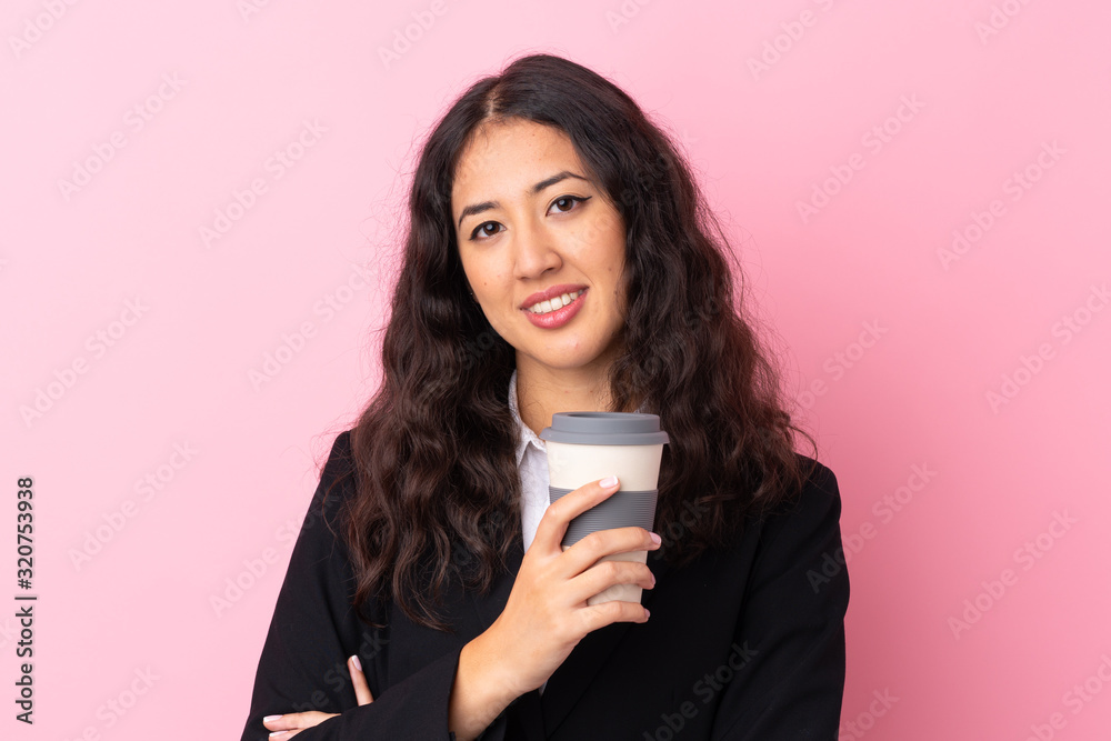 Mixed race business woman holding coffee to take away over isolated pink background Mixed race business woman holding coffee to take away over isolated pink background