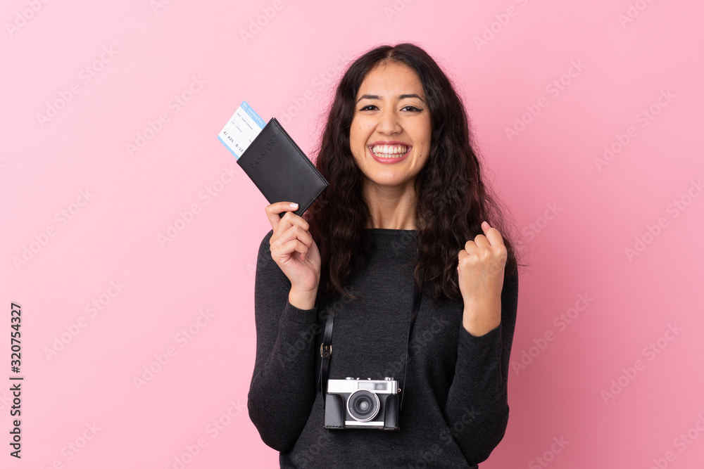 Mixed race woman over isolated pink background happy in vacation with passport and plane tickets Mixed race woman over isolated pink background happy in vacation with passport and plane tickets