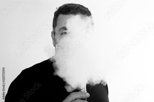 sad mature man smokes an electronic cigarette