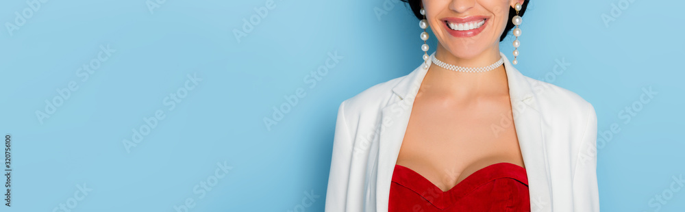panoramic shot of smiling woman on blue background