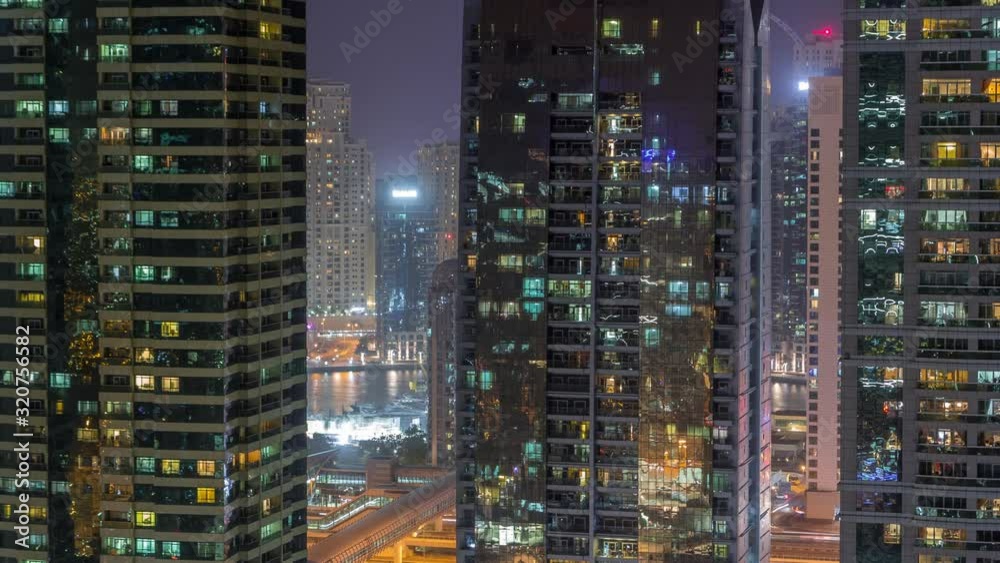 Residential and office buildings in Jumeirah lake towers district night timelapse with blinking lights in windows in Dubai. Aerial view from above with modern skyscrapers Residential and office buildings in Jumeirah lake towers district night timelapse with blinking lights in windows in Dubai. Aerial view from above with modern skyscrapers