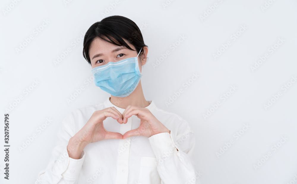 Asian woman showing heart gesture with two hands and looking at camera Asian woman showing heart gesture with two hands and looking at camera