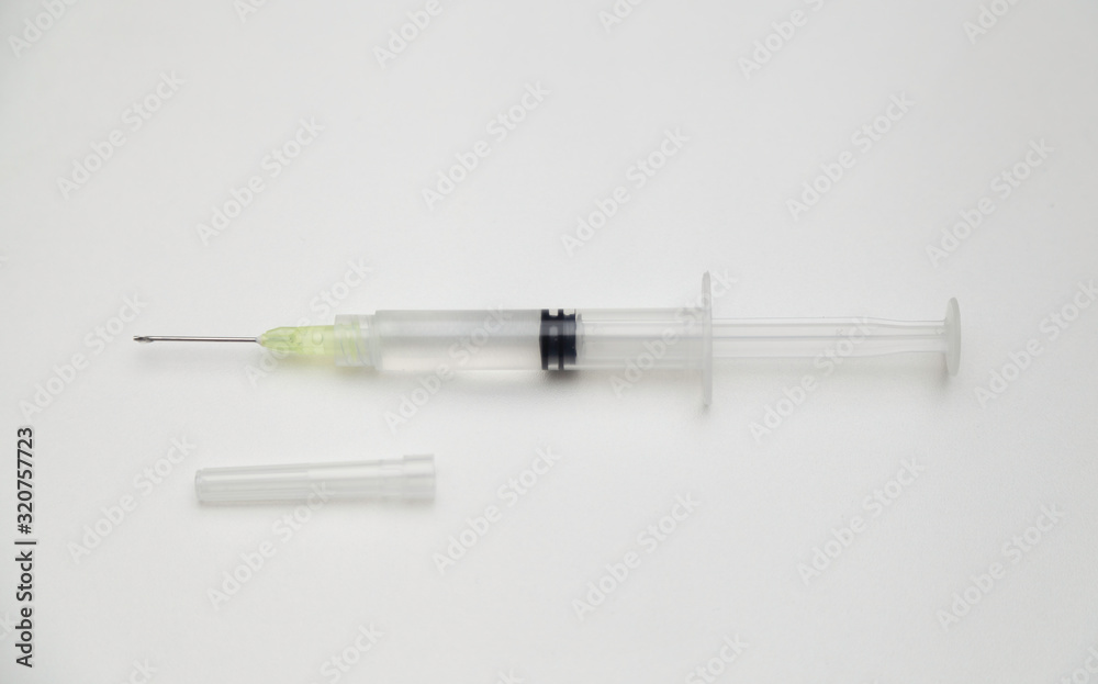 Syringe on white background with cap Syringe on white background with cap