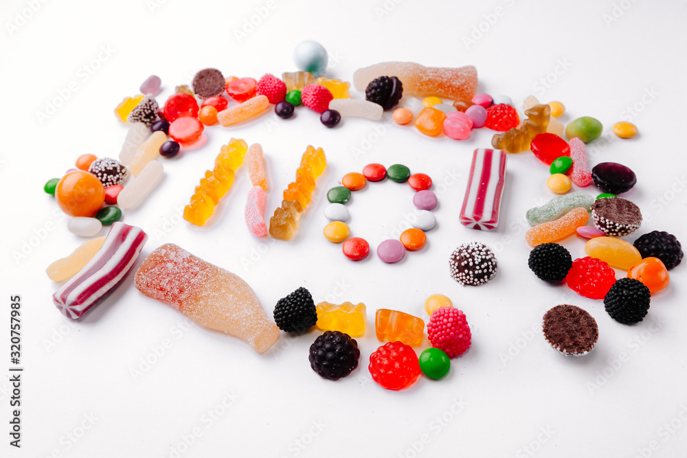 Concept no sweets, colorful candies, jelly and marmalade on white background. Flat lay, top view Concept no sweets, colorful candies, jelly and marmalade on white background. Flat lay, top view