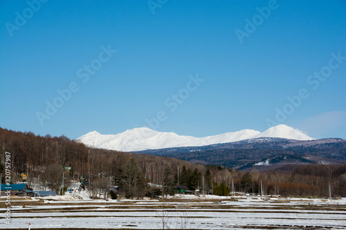 発の農村地帯と雪山 大雪山