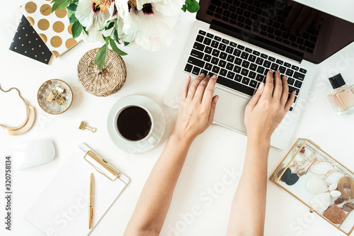 Woman hands work on laptop. Home office desk table workspace with laptop on white background. Flat lay, top view freelance work concept.